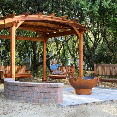 Ti Amo Benches (Options: 6 ft, California Redwood, No Cushion, No Engraving, Transparent Premium Sealant). Photo Also Shows an Arched Pergola with Bench Swing Seats. Photo Courtesy of Tom Marten of Kitty Hawk, North Carolina.