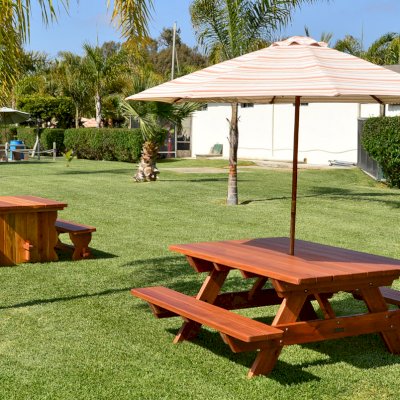 Trestle Natural Wood Outdoor Table (Options: 5' L, 34 1/2'' W Tabletop, Side Benches, Redwood, Standard Tabletop, No Umbrella Hole, Slightly Rounded Corners, 2 Full Length Side Benches, Transparent Premium Sealant) and Forever Picnic Table with Attached Benches.