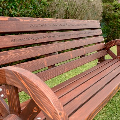 Wagon Wheel Wooden Bench (Options. 6 ft, Mature Redwood (20-yr Warranty) , No Cushion, Custom Engraving - 51-100 chars, Cherry Stain Premium Sealant).