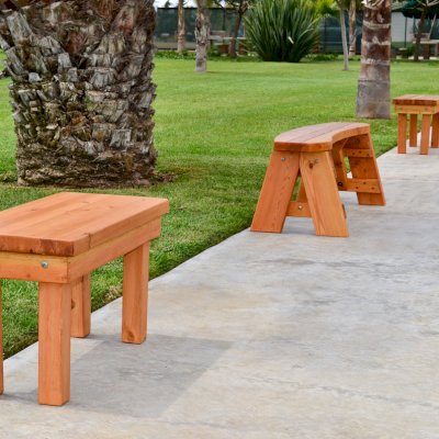 Wood Patio Bench (Options: 3 1/2 ft x 14 1/4 inches W x 18 1/2 inches H, Douglas-fir, No Cushion, No Engraving, Cherry Stain Premium Sealant). Photo also shows some round picnic benches.